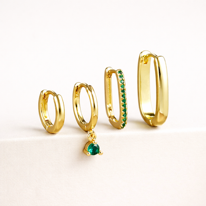 The Sabrina SET is shown in a green crystal colorway, with pave and dangling stones on two of the four gold hoops.