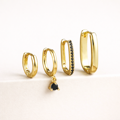 The Sabrina SET is shown in a black crystal colorway, with pave and dangling stones on two of the four gold hoops.