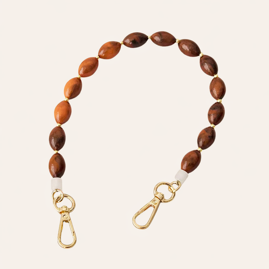 Wood-tone oval beaded Saffron short phone strap coiled flat with gold-tone clasp ends.