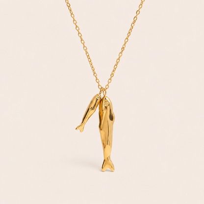 Gold chain necklace with two textured sardine fish charms from the Sardina NECKLACE design, laid flat on beige.