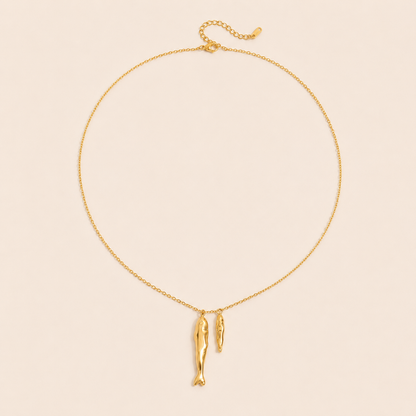Gold Sardina NECKLACE with two fish charms and an adjustable clasp, shown fastened in a circle on a beige background.
