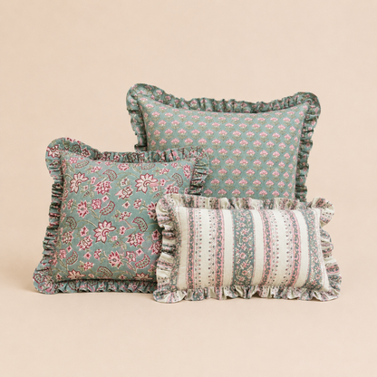 Teal square cushion with a repeating droplet peacock-feather print in rust and cream, finished with a ruffled edge, Vive cushion collection.
