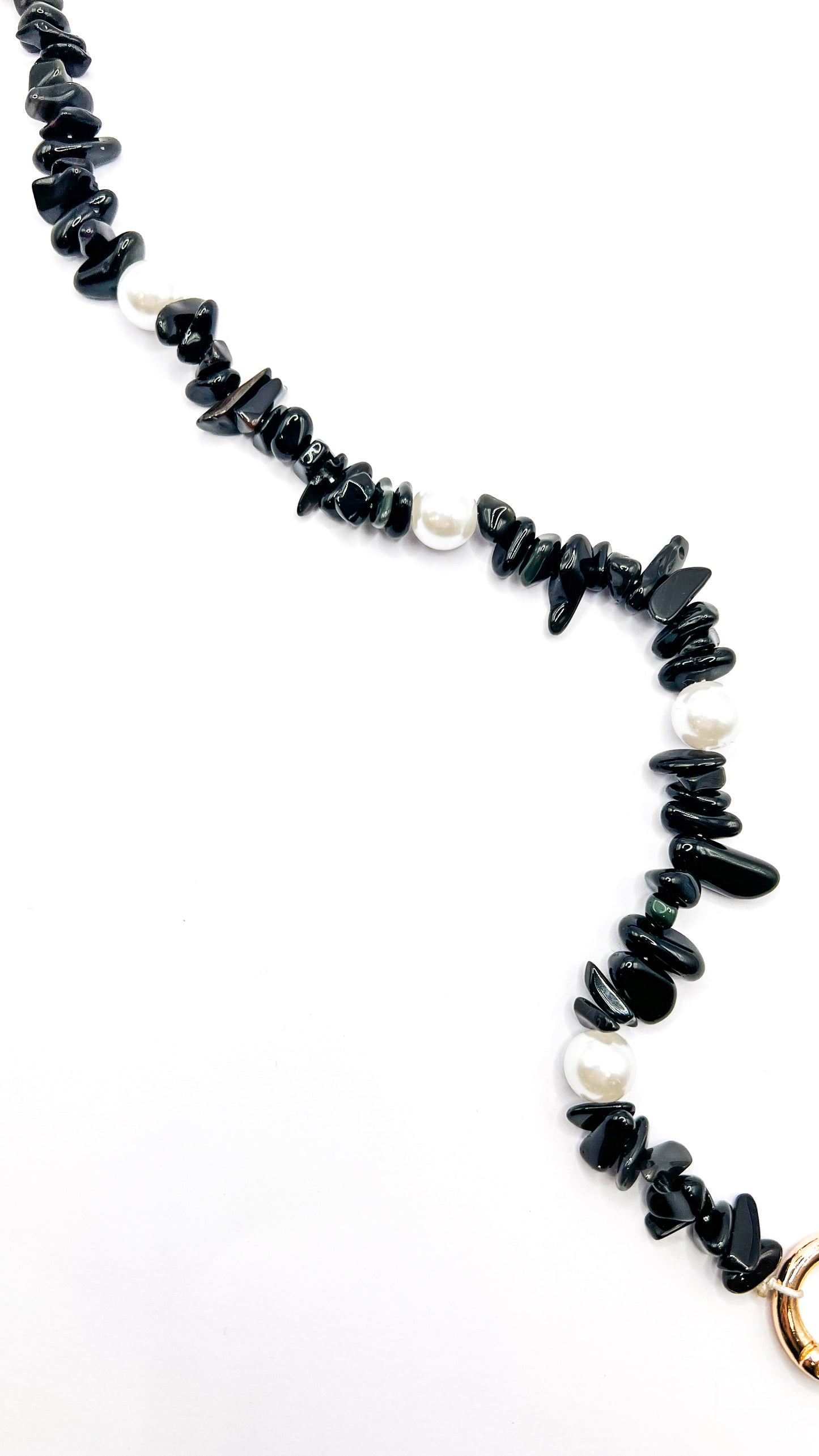 Close-up of a black beaded Shell Whisper SHORT PHONE STRAP, chip beads and pearls, gold clasp visible at the edge.