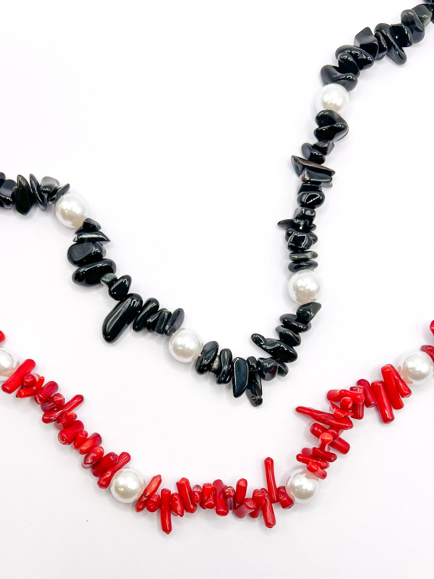 Black and red beaded Shell Whisper SHORT PHONE STRAP colorways shown together in close-up, chip beads with pearl accents.