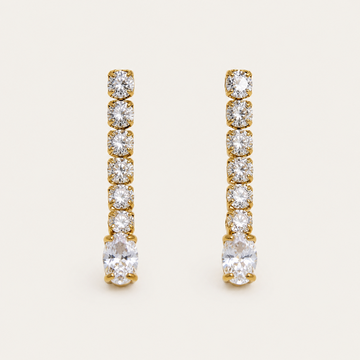 Gold linear drop earring with graduated round zirconia stones ending in a marquise-cut stone — Folie à Trois Shimmer EARRINGS.