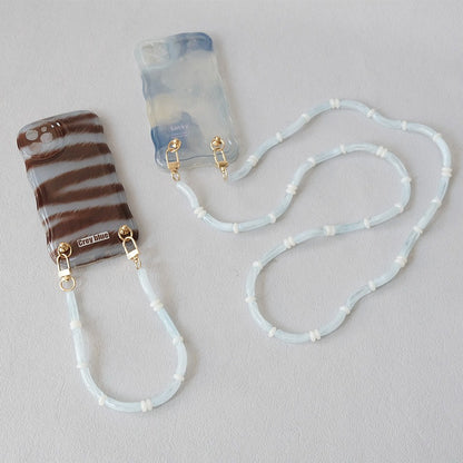 Light blue Smooth Moves PHONE CHAIN attached to a zebra-print phone case and a blue tie-dye phone case.