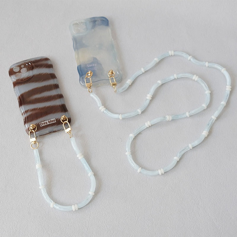 Light blue Smooth Moves PHONE CHAIN attached to a zebra-print phone case and a blue tie-dye phone case.