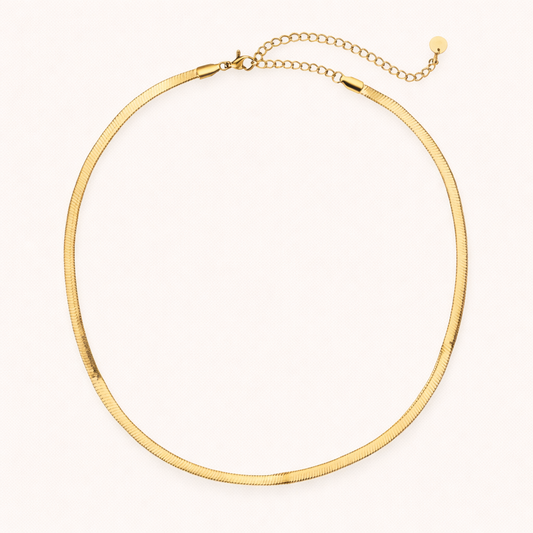 The Snake Skin NECKLACE in gold, a flat herringbone chain with a lobster clasp and adjustable extender, shown on white.