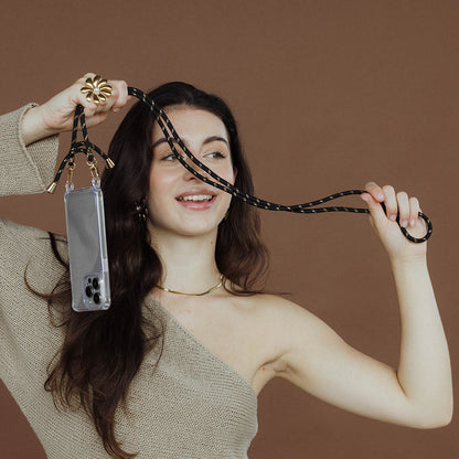 The Snake Skin NECKLACE in gold worn faintly at the neckline while the model holds up a beaded phone strap and case.