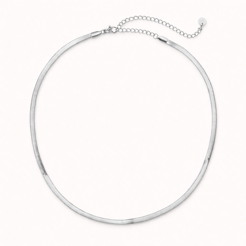 The Snake Skin NECKLACE in silver, a flat herringbone chain with a lobster clasp and adjustable extender, shown on white.