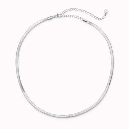 The Snake Skin NECKLACE in silver, a flat herringbone chain with a lobster clasp and adjustable extender, shown on white.