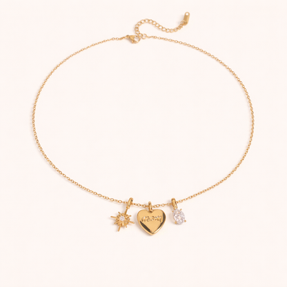 The Soft Power NECKLACE laid flat, its gold star, engraved mom heart, and crystal charms shown on a fine chain with extender.