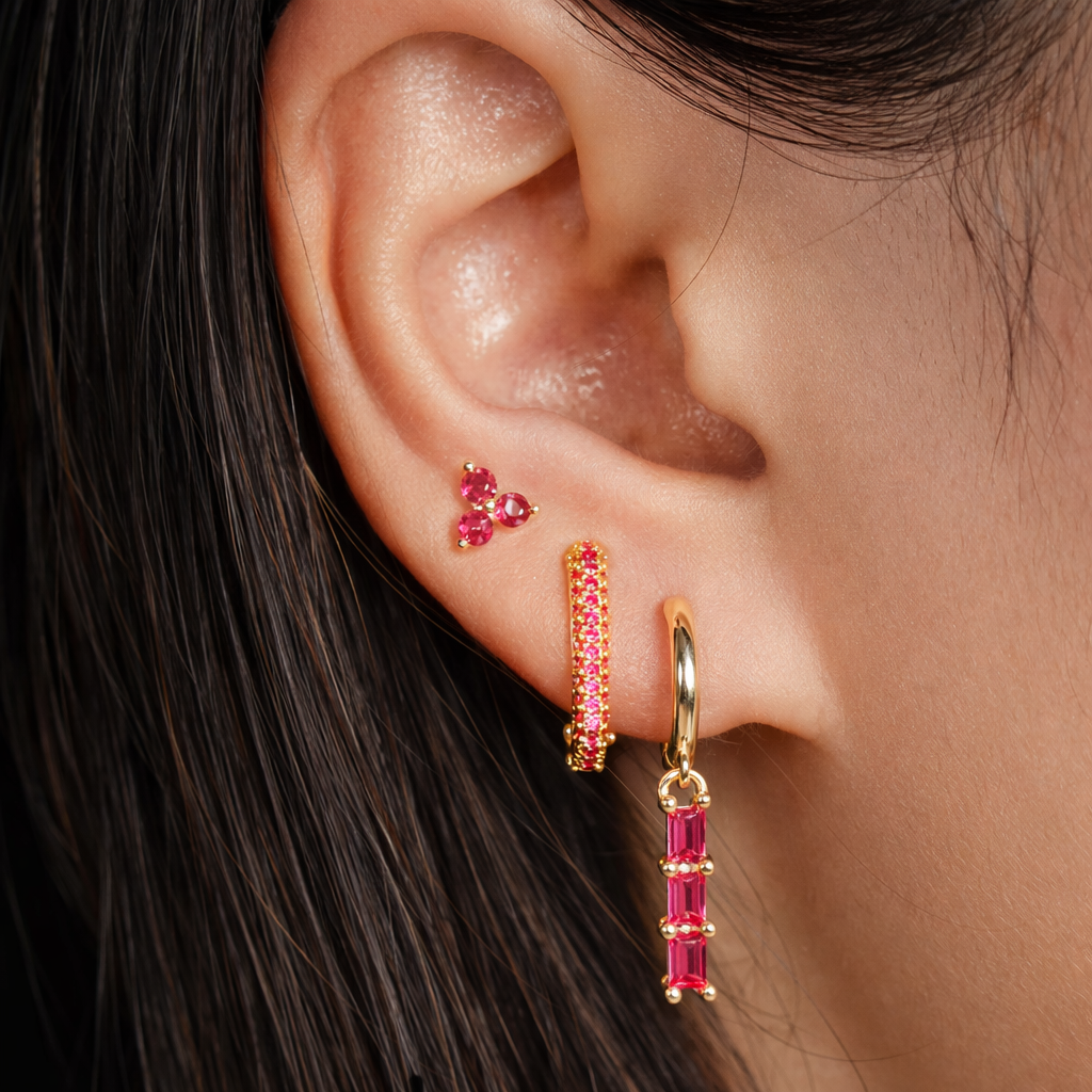 Worn along the ear, the Solaire SET is shown in pink, with a trio stud, baguette drop, and pave hoop.