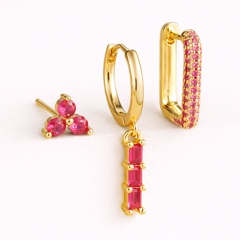 The Solaire SET is shown in a pink crystal colorway across its trio stud, drop huggie, and pave hoop.