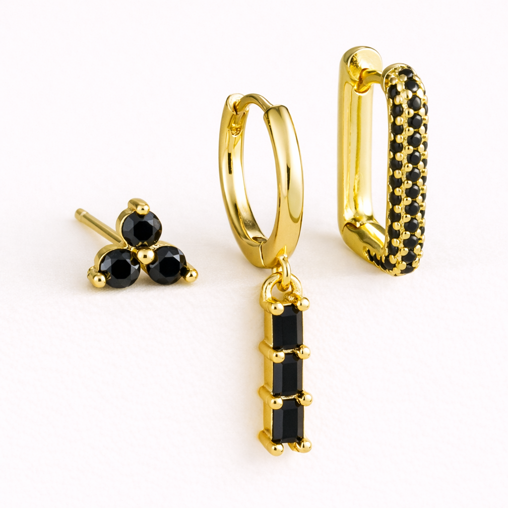 The Solaire SET is shown in a black crystal colorway across its trio stud, drop huggie, and pave hoop.