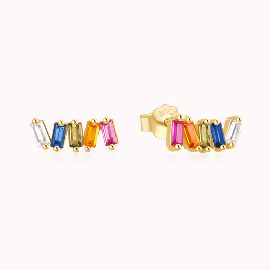 Solara Earrings line up five multicolor baguette stones in a gold curved row, from clear to blue, olive, orange, and pink.