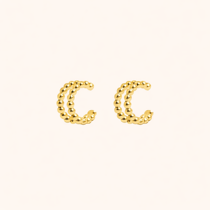 The Solara EARCUFF in gold, a pair of double-band beaded cuffs shown side by side on a cream background.