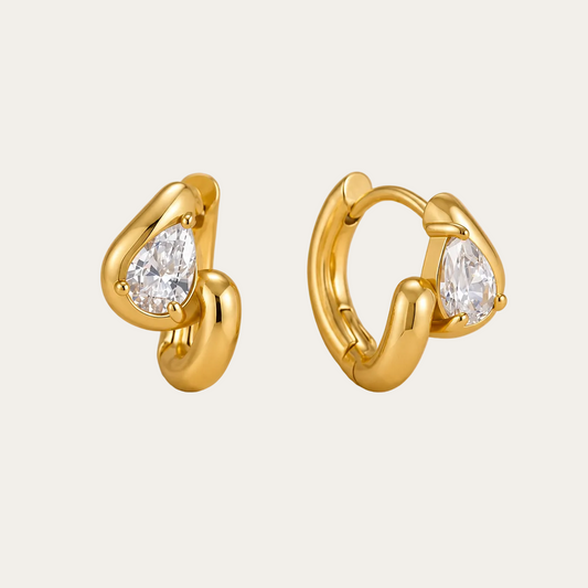Gold heart-shaped huggie hoop earring with a pear-cut white zirconia stone bezel-set at the top — Folie à Trois Sombra EARRINGS.