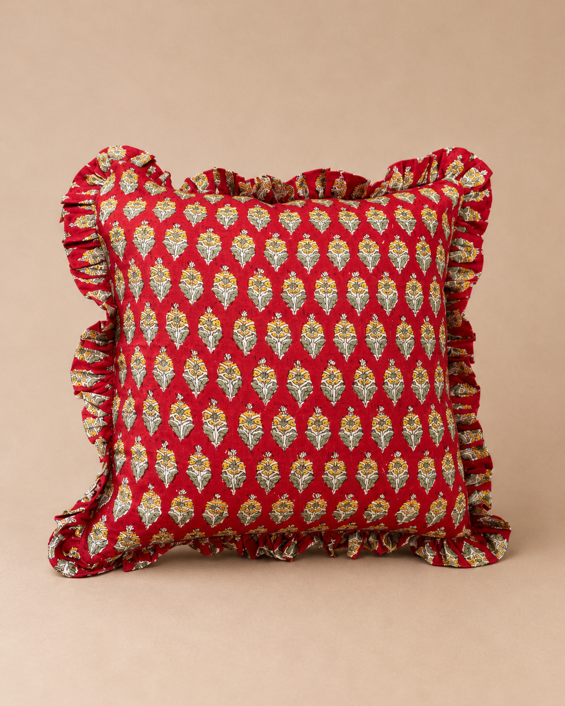 Red square cushion with a repeating cream and yellow floral bud print and ruffled trim, the Sonal Red Square Cushion on a neutral backdrop.