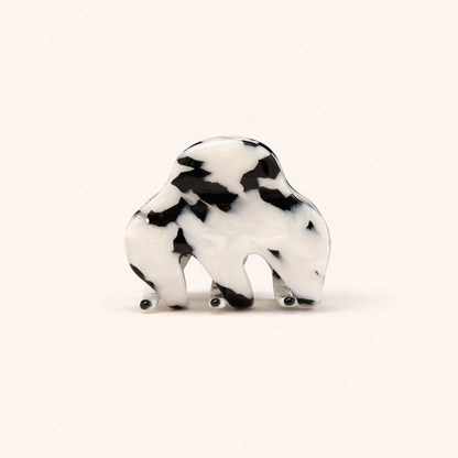 A black and white mottled tortoiseshell Soul On The Line HAIR CLIP shaped like a bison, shown on a plain background.