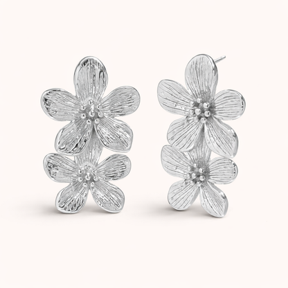 The Spring Bloom EARRINGS are shown in polished silver, with two textured flowers stacked along the ear.