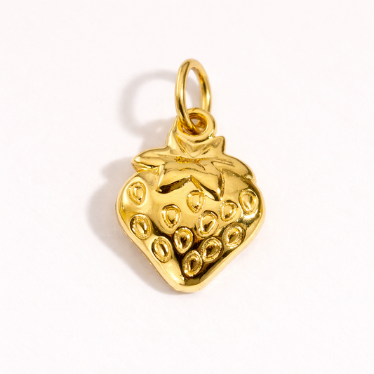 The Strawberry CHARM in gold, textured with seed detailing and a leafy top, shown alone on a plain white studio background.