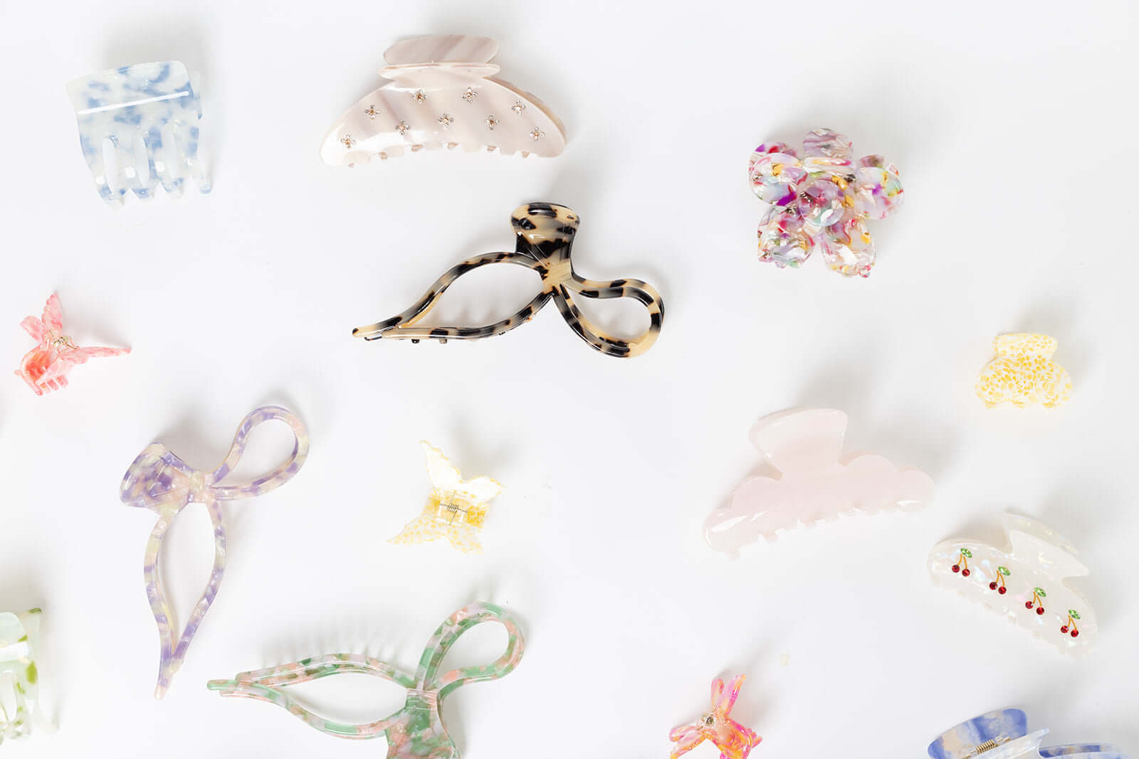 Summer Bliss HAIR CLIP shown among a wide flat-lay assortment of differently shaped acetate hair clips in various colors and patterns.
