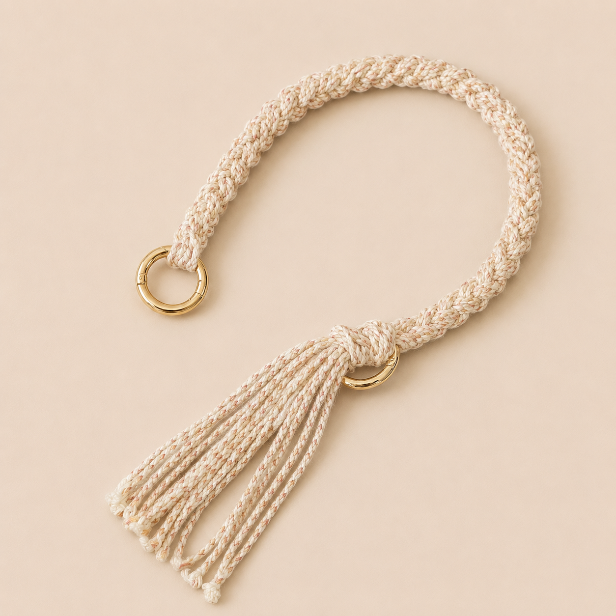 Cream and tan braided Sundaze phone strap with a fringed tassel and gold ring hardware.