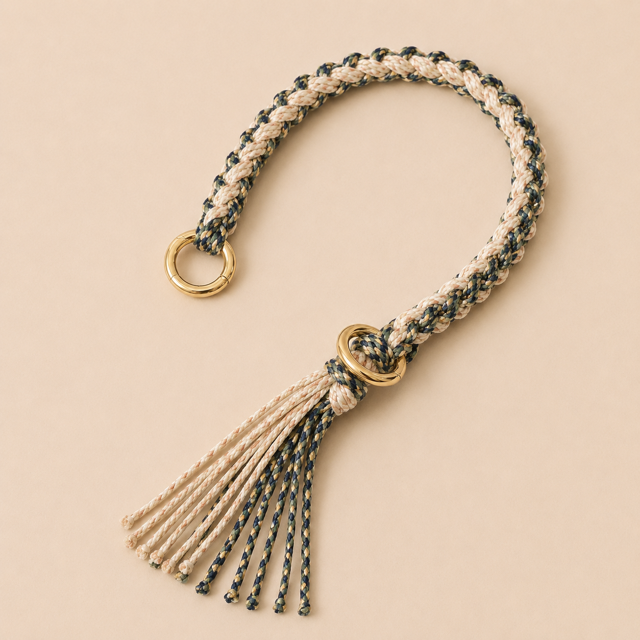 Cream, navy, and olive braided Sundaze phone strap with a fringed tassel and gold ring hardware.