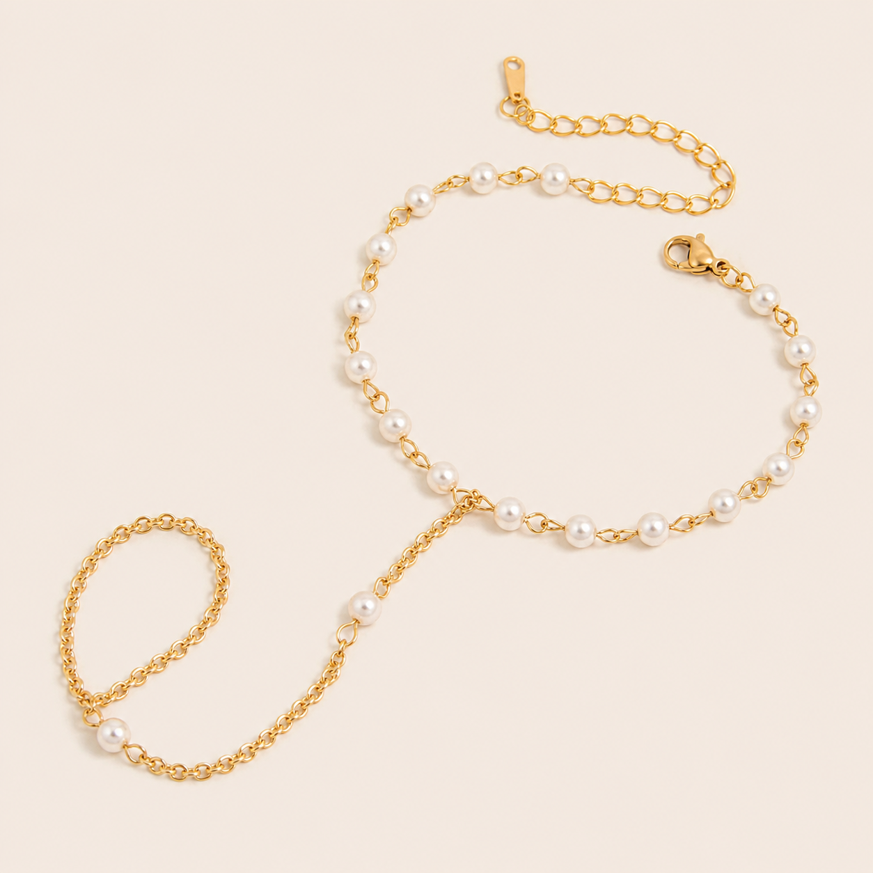 Sunseeker Hand Chain BRACELET in gold with small pearls beaded along the wrist chain and ring connector, shown flat.