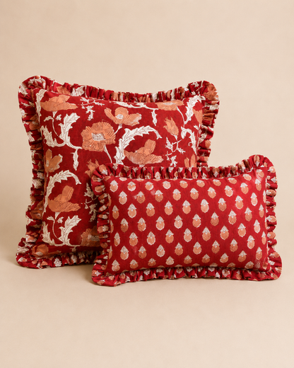 Sunset Flame Cushion SET pairing a red poppy floral square cushion with a smaller paisley-print rectangle cushion, both edged with ruffles.
