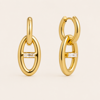 Gold oval link drop earring with a horizontal baguette-cut white zirconia stone at its center — Folie à Trois Talia EARRINGS.