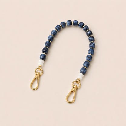 Blue marbled bead phone chain with white spacers and gold clasps on cream — Folie à Trois Teagan wholesale phone chain