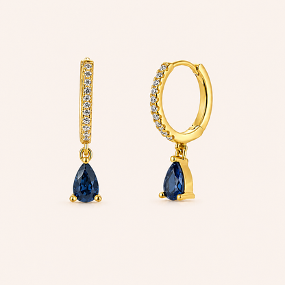 Teardrop Earrings in gold with sapphire-blue crystals, showing the pave hoop and pear-cut crystal drop design.