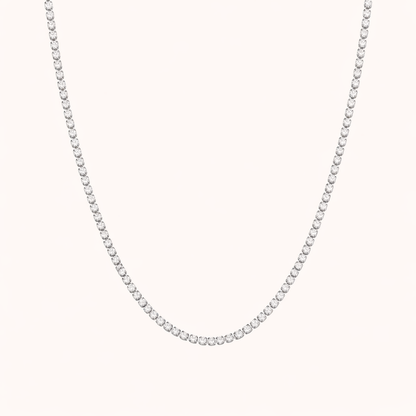 The Tennis NECKLACE in silver, a single row of round cubic zirconia stones set in a delicate chain, shown flat.