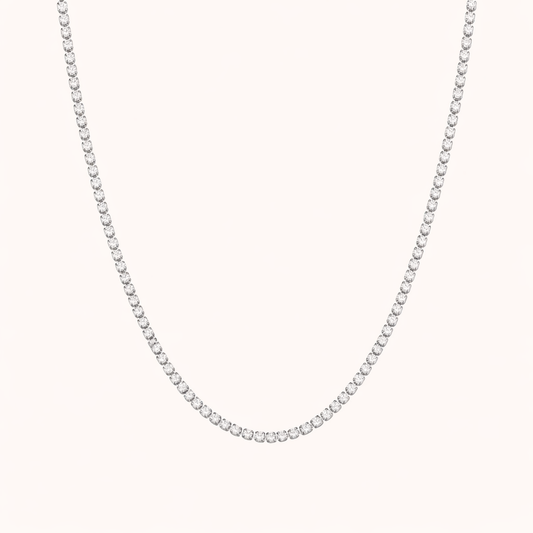 The Tennis NECKLACE in silver, a single row of round cubic zirconia stones set in a delicate chain, shown flat.