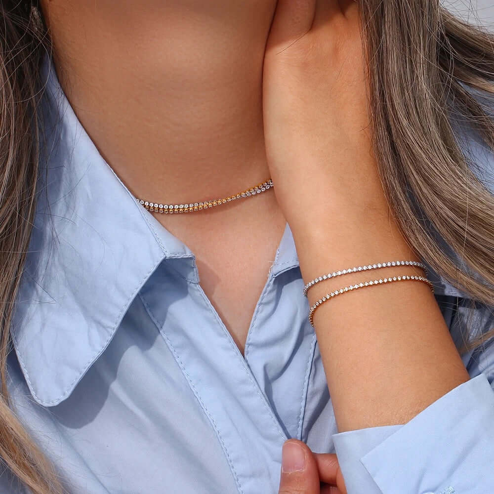 The Tennis NECKLACE in silver worn as a choker, layered above a matching tennis bracelet stacked on the wrist.