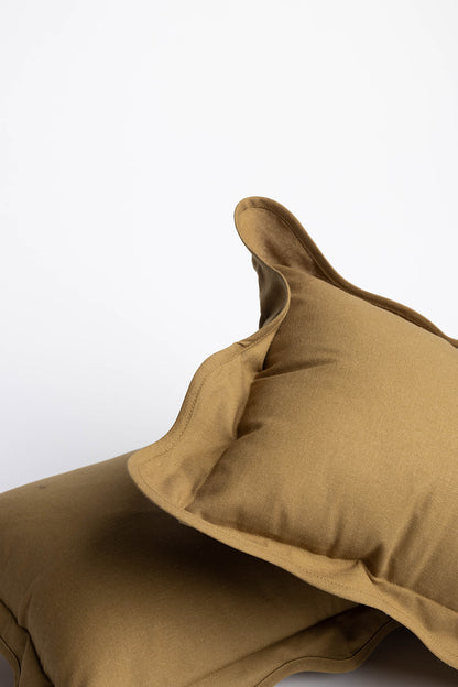 Flat lay of the Terry Rectangle Linen cushion with a cream center panel framed by a khaki scalloped border and contrast stitching.