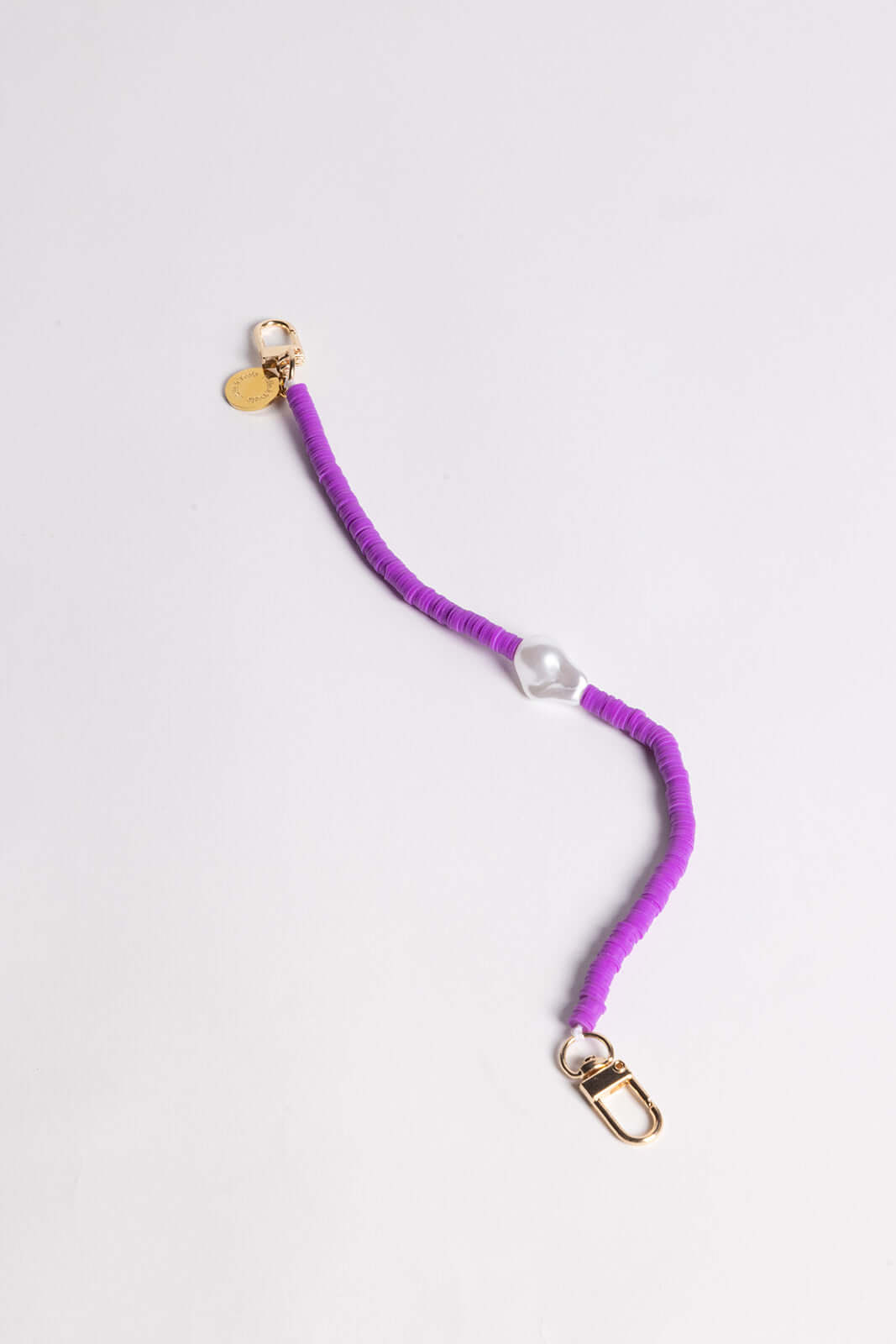 A purple heishi bead phone cord with a clear bead and gold clasps, shown on a white background.