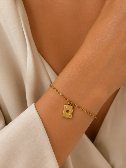 Gold ace of hearts card charm from the Signature Charms BUNDLE, worn on a chain bracelet close-up on the wrist.