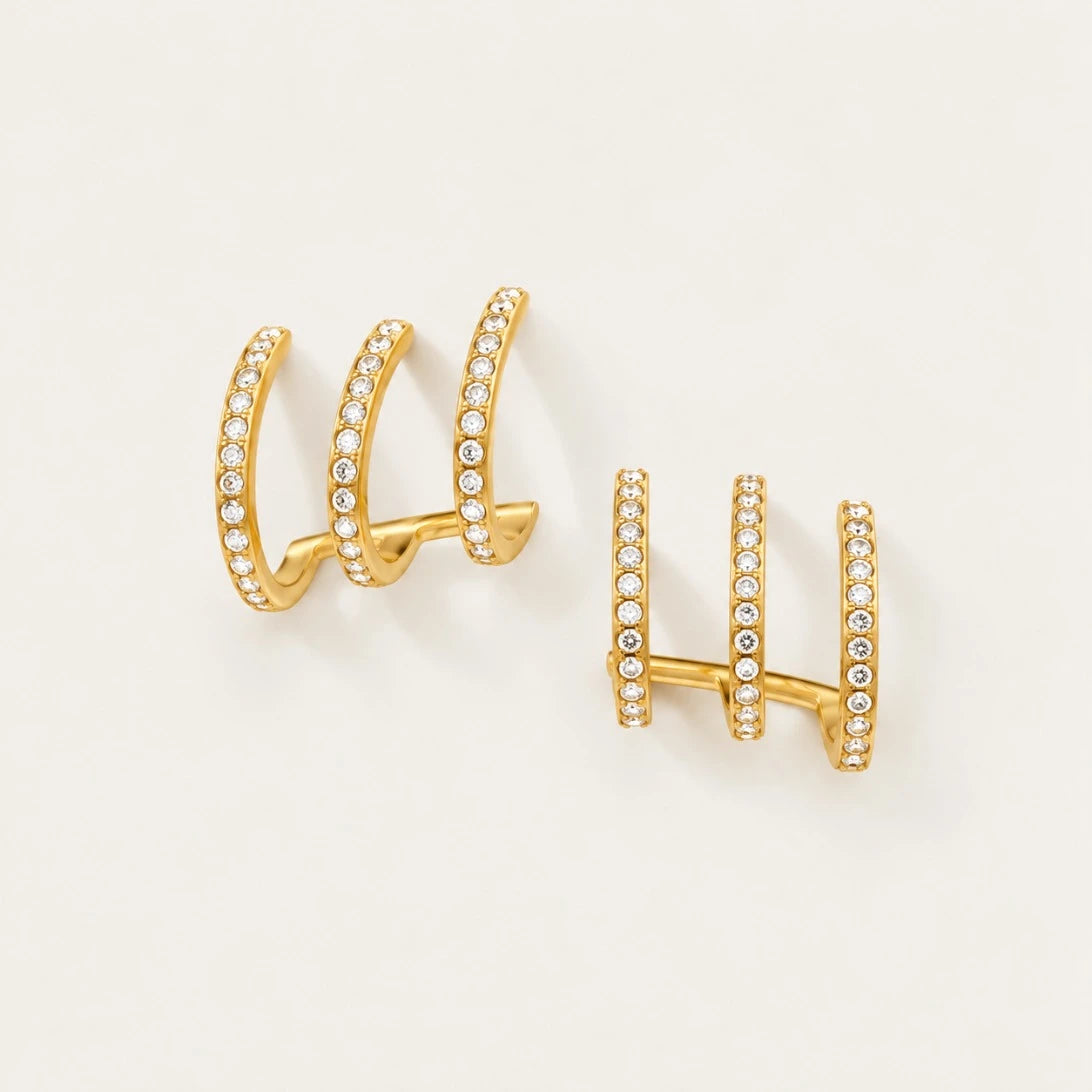 Pair of gold Triad EARRINGS with three parallel zirconia pavé bands on a cream background — Folie à Trois wholesale