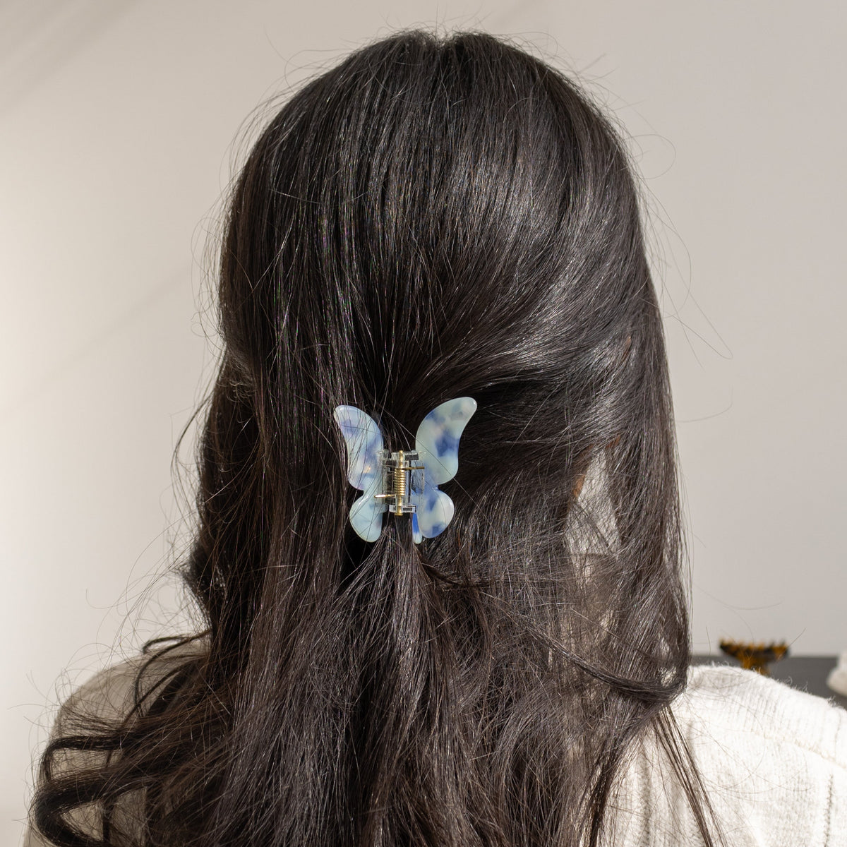 True Paradise HAIR CLIP's blue and white butterfly clip worn in half-up dark hair.