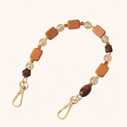 Mixed wood and glass beaded Tulum short phone strap coiled flat with gold-tone clasp ends.