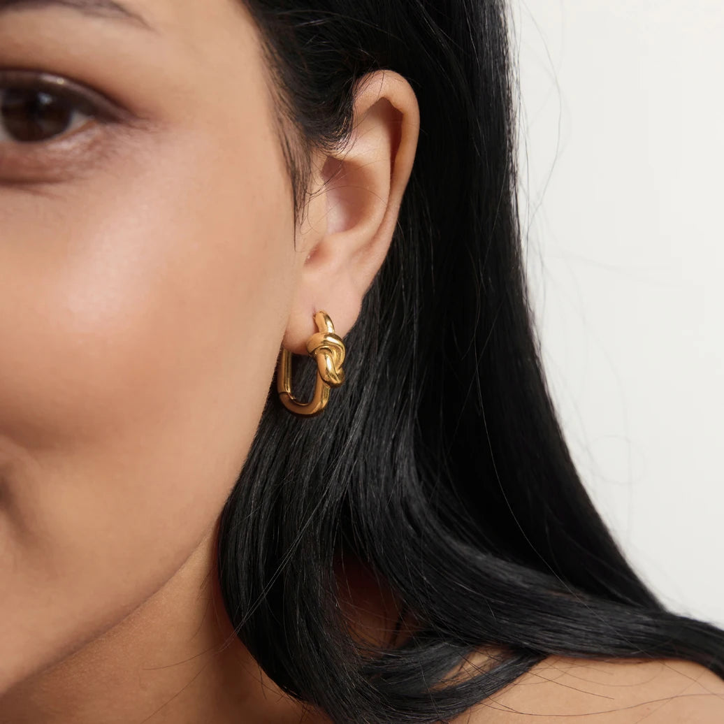 Gold Twine EARRINGS worn by a model with long black hair, a knotted huggie hoop on the lobe — Folie à Trois