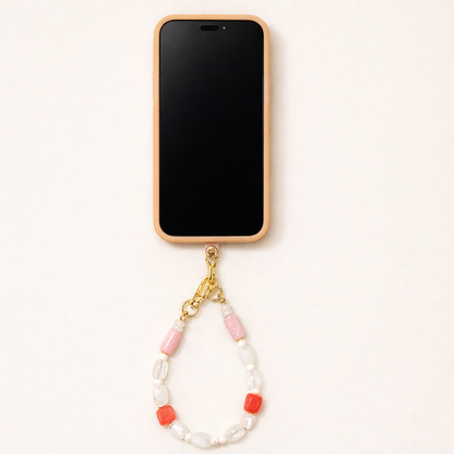 Cream phone case fitted with the Universal Phone Adapter, connected to a white, pink, and coral beaded phone strap with gold clasps.