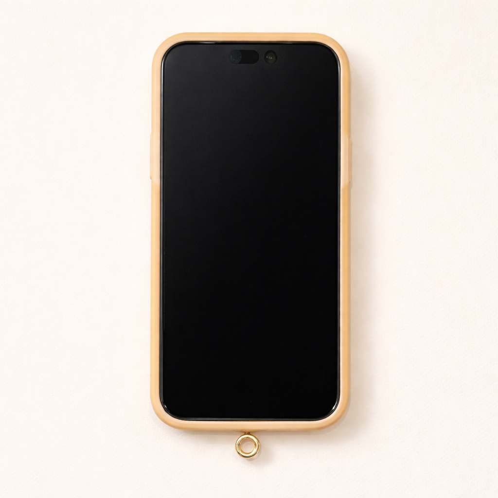 Close-up of a cream phone case with a gold-trimmed edge and the Universal Phone Adapter gold attachment ring at the bottom.