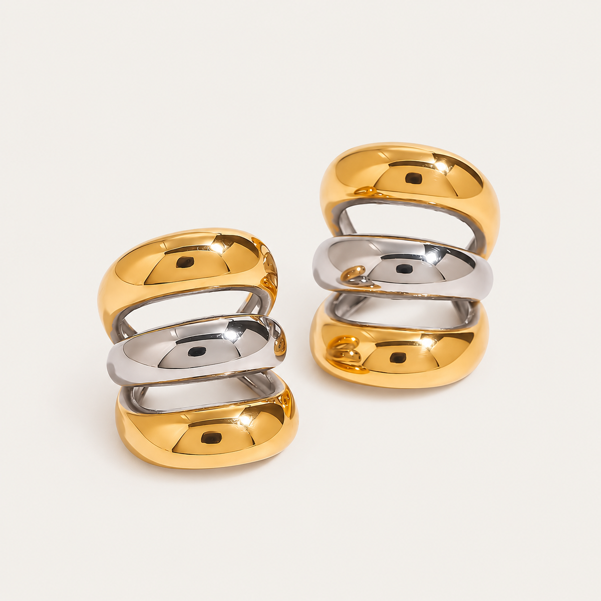 Gold and silver two-tone triple-band ear cuffs shown from an angle, product shot for the Folie à Trois Unruly EAR CUFF.