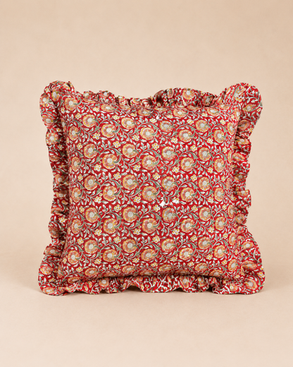 Red square cushion with a cream and yellow floral medallion block print and matching ruffled trim, the Varsha Red Square Cushion.