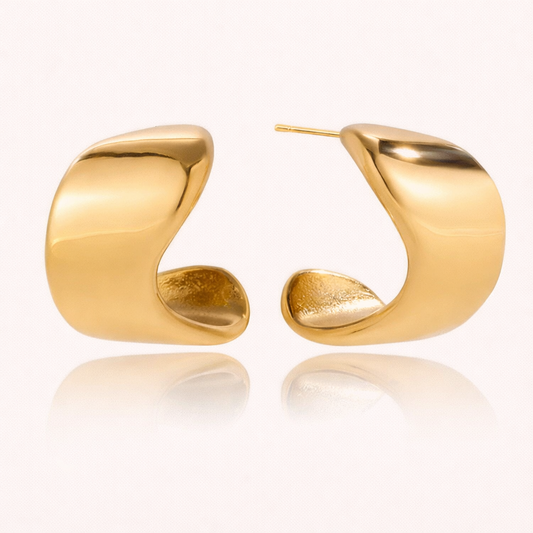 Verbier Earrings in gold, a sculptural wave-shaped hoop with a smooth curved silhouette, shown as a pair.