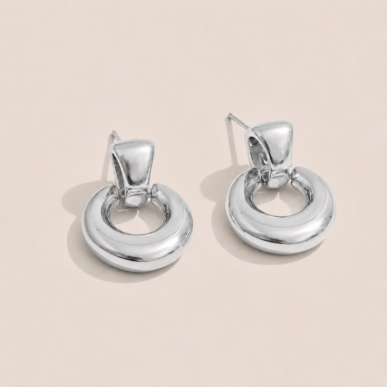 Silver chunky doorknocker earrings with a bold rounded hoop on a cream backdrop — Folie à Trois Verve EARRINGS